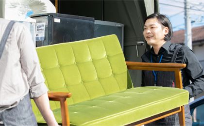 ソファをトラックに運ぶ男性スタッフ